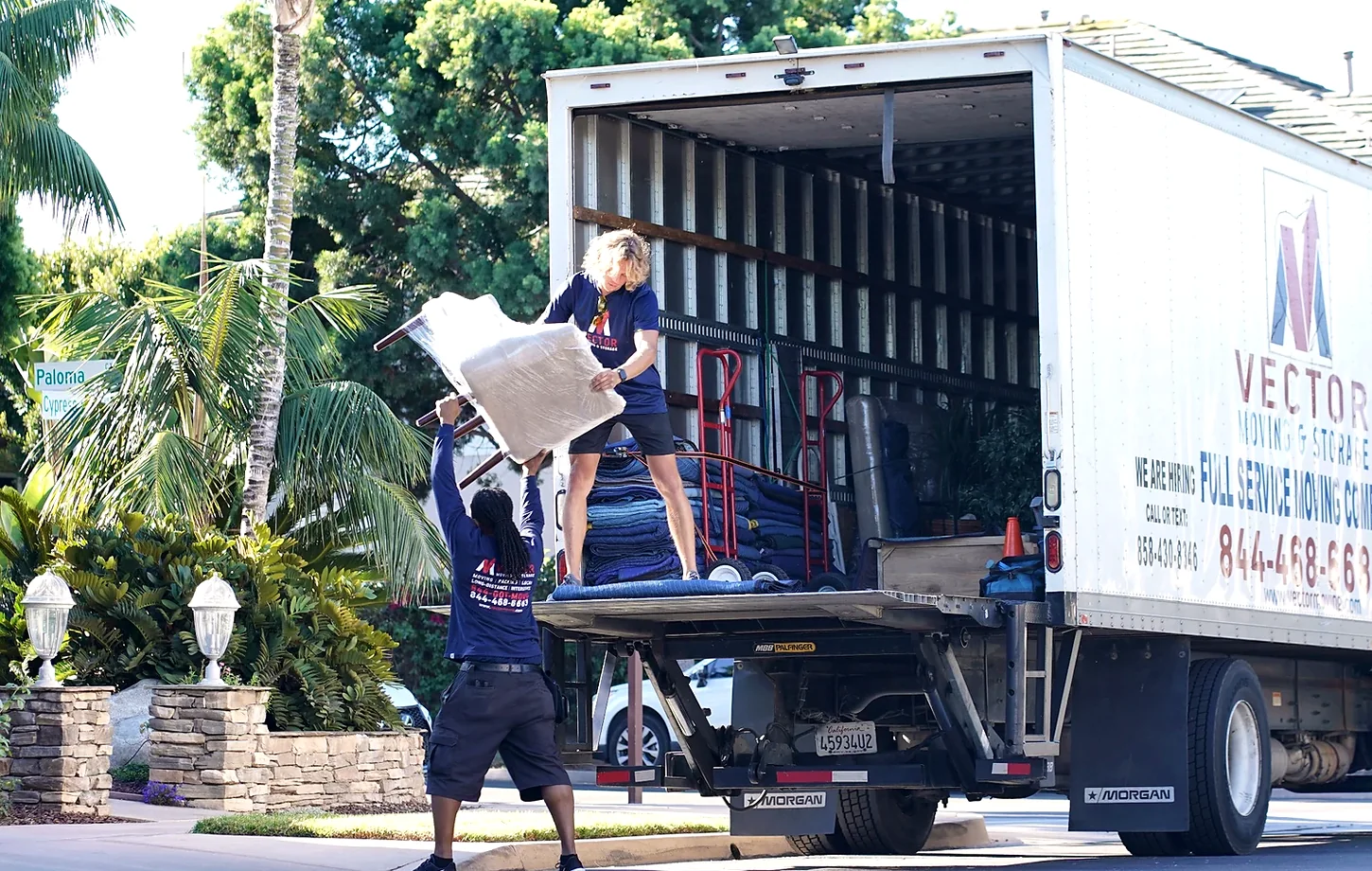 Vector movers transferring protected furniture during a residential move