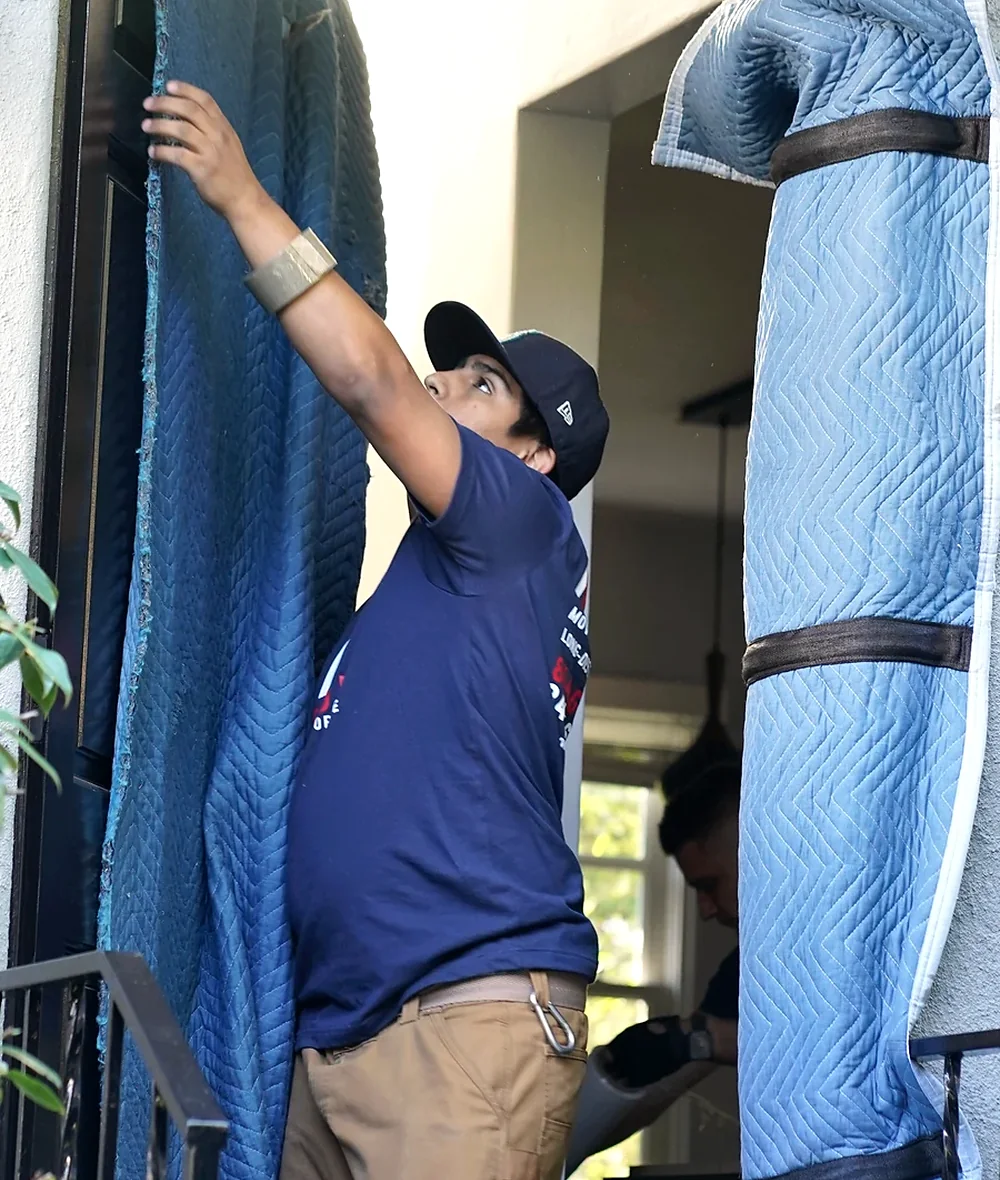 Vector mover installing padded doorway protection before a move