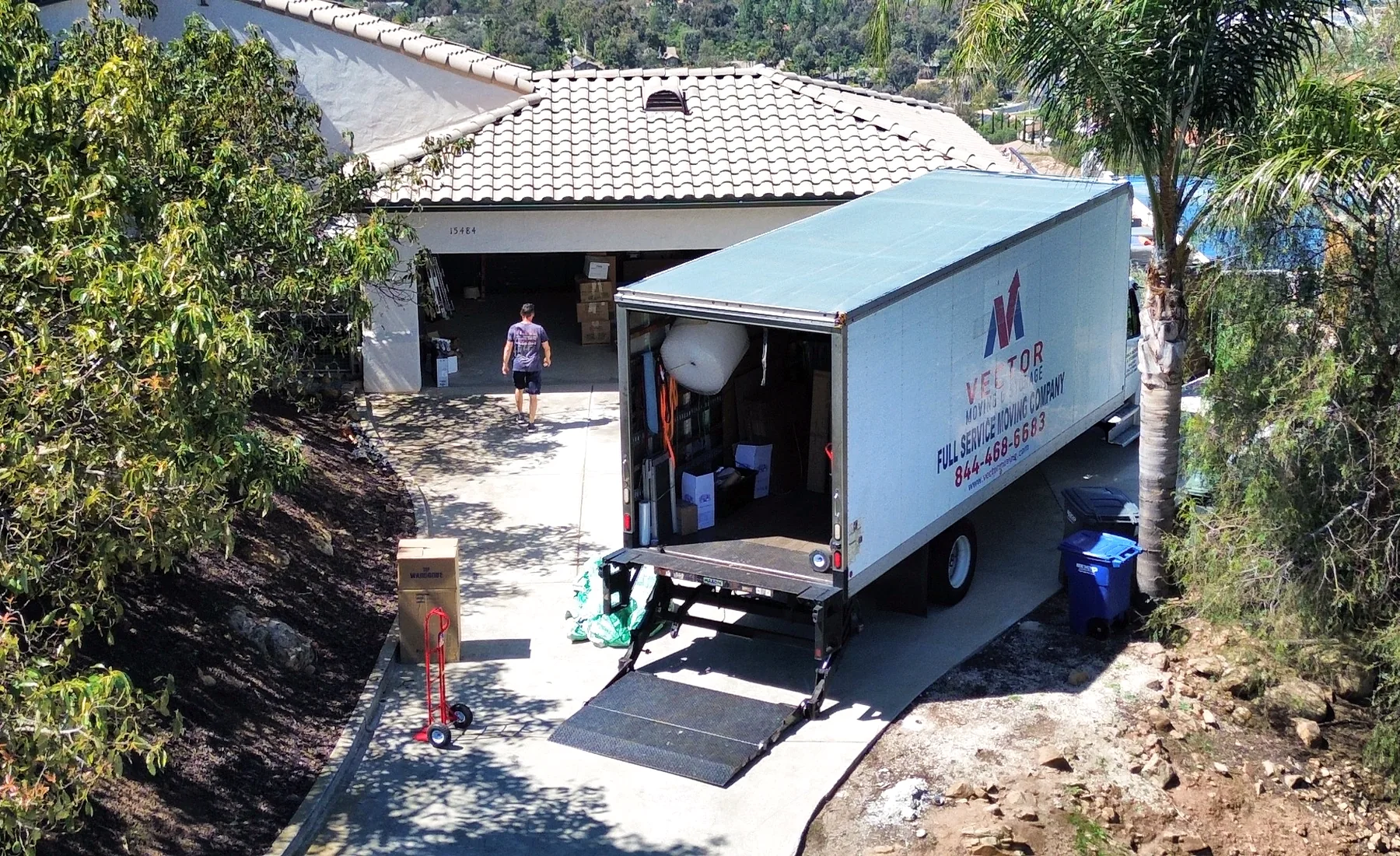 Vector moving truck positioned on a long sloped residential driveway