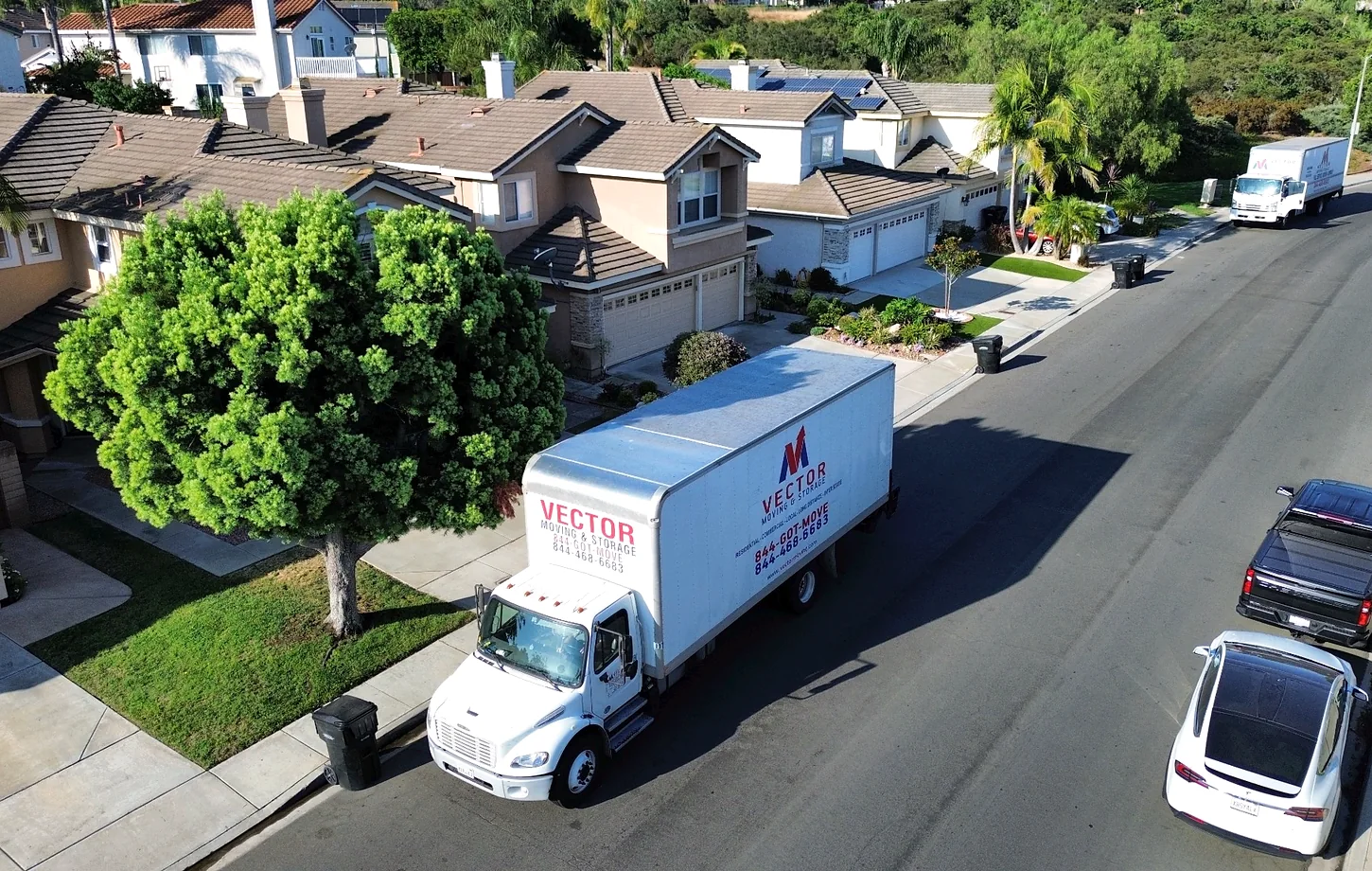 Vector moving trucks on a residential street with curb and vehicle access considerations