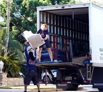 Vector movers loading protected furniture into a branded moving truck