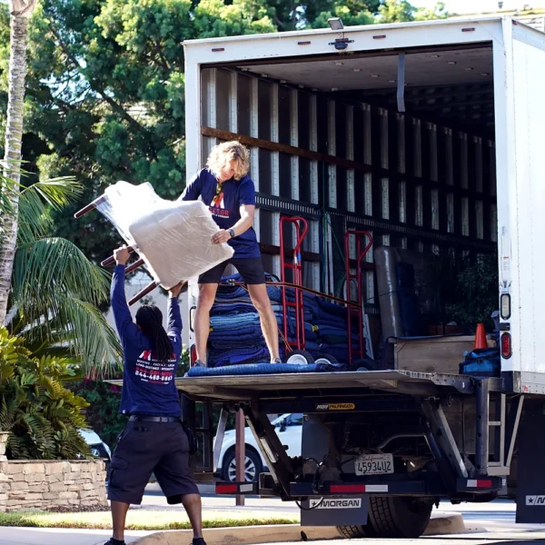 Vector movers loading protected furniture into a branded moving truck
