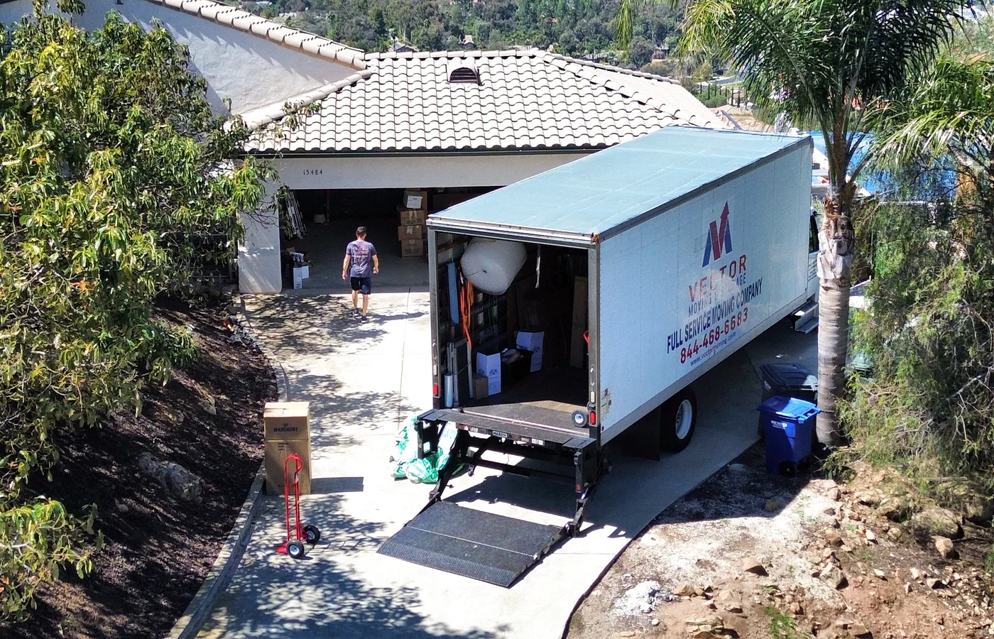 Vector moving truck positioned on a sloped residential driveway