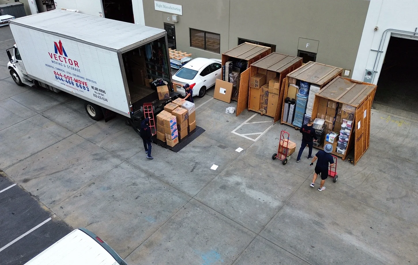 Vector crew loading boxes between a moving truck and wooden storage vaults