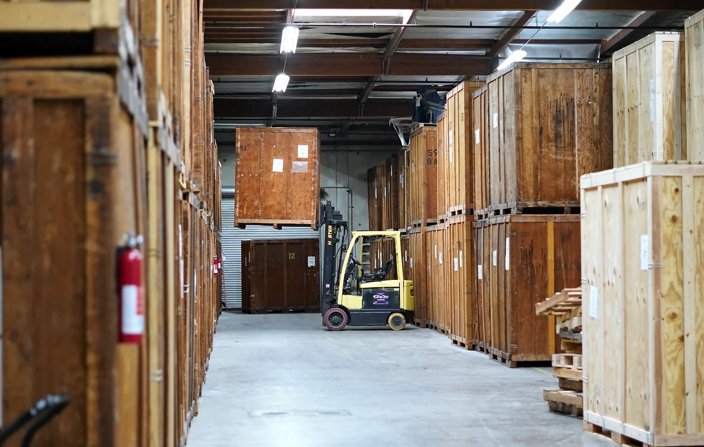 Wooden storage vaults and forklift inside the Vector Moving and Storage warehouse