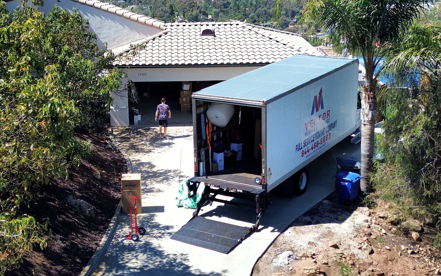Vector moving truck positioned on a sloped residential driveway