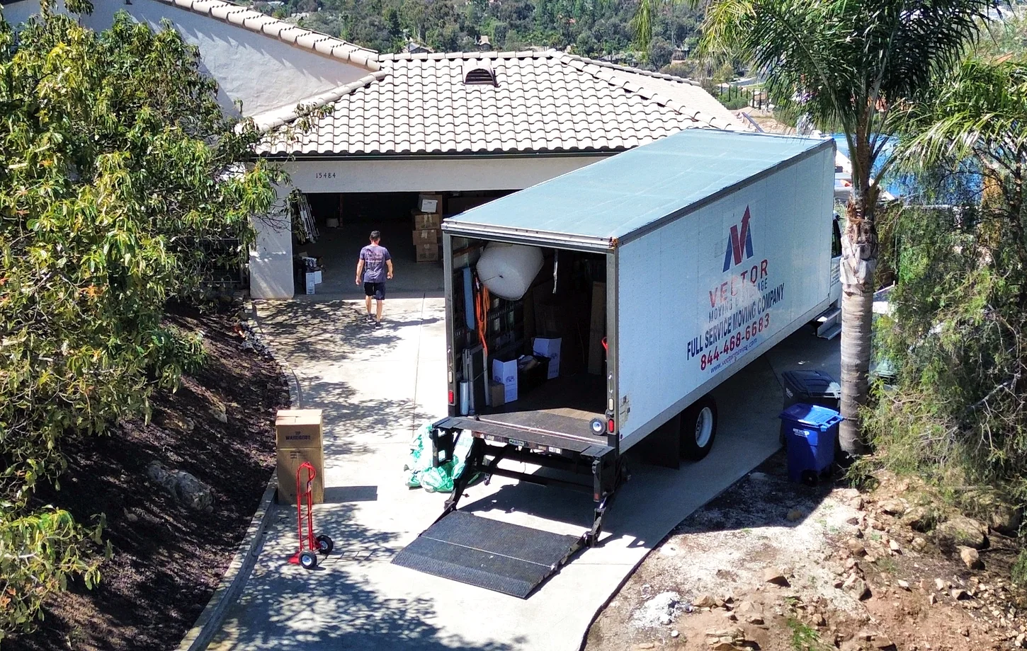Vector moving truck positioned on a sloped residential driveway