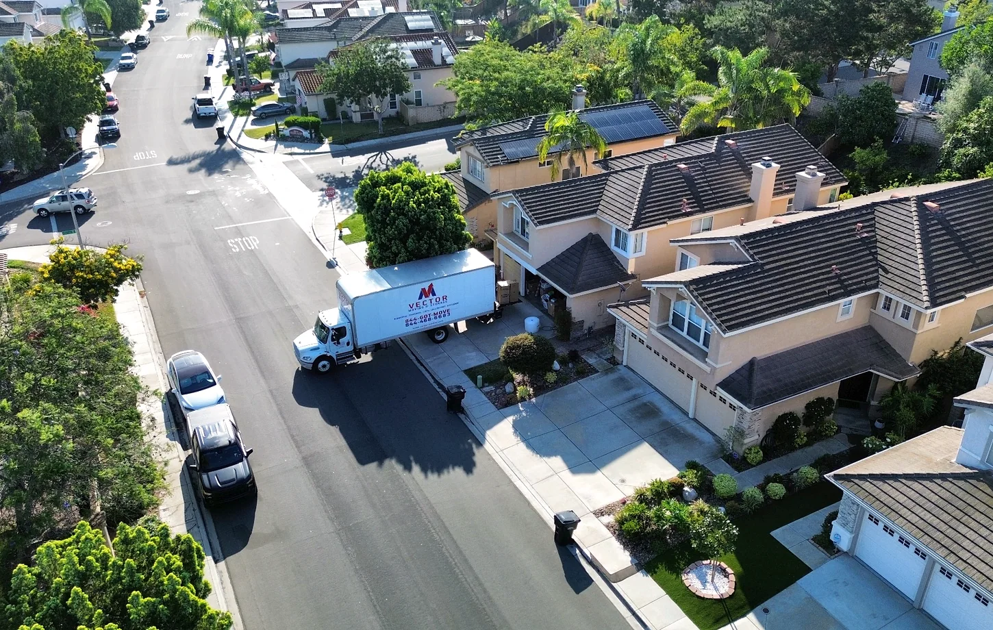 Vector moving truck at a landscaped residential property with neighborhood street access
