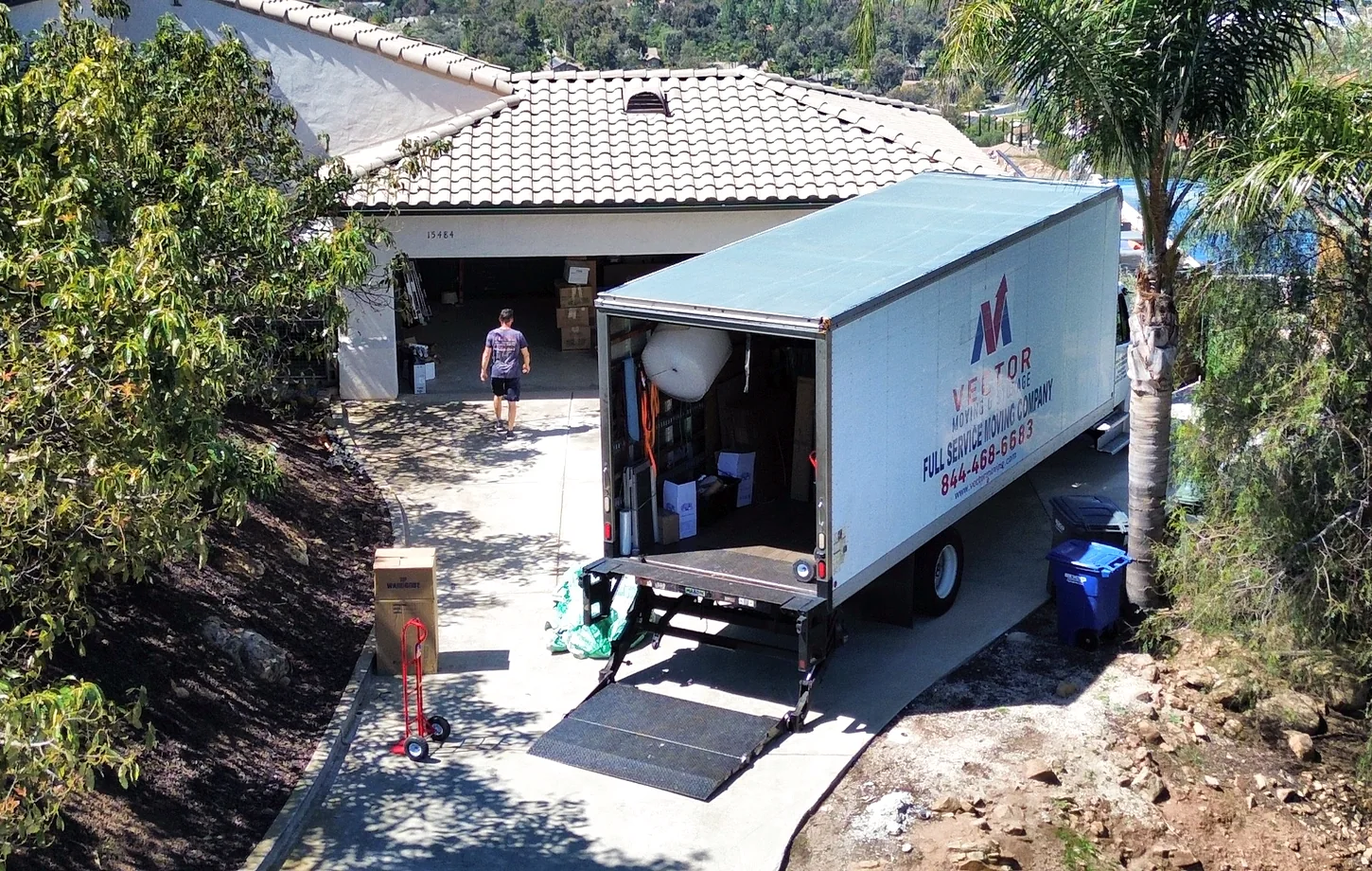 Vector moving truck positioned on a sloped residential driveway