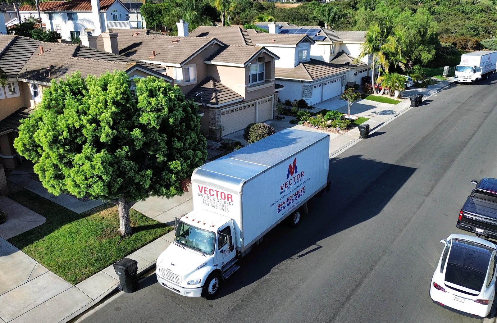 Vector Moving and Storage truck in a landscaped residential neighborhood