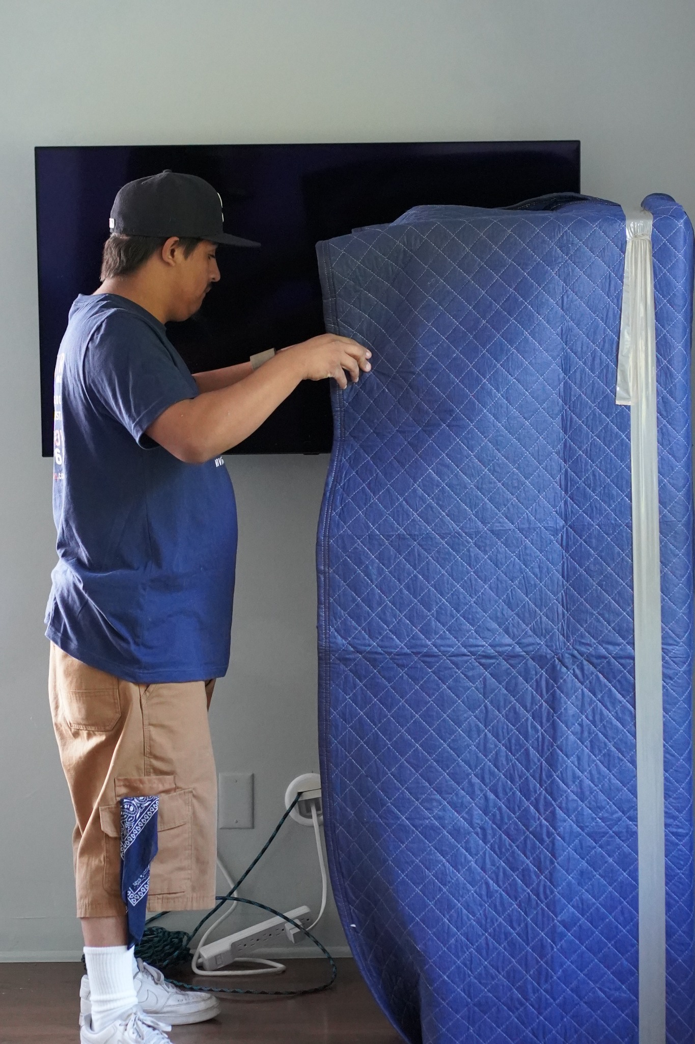 Vector mover wrapping household furniture with a protective moving blanket