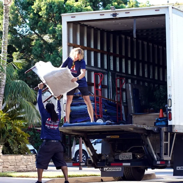 Vector movers loading protected household furniture into a moving truck