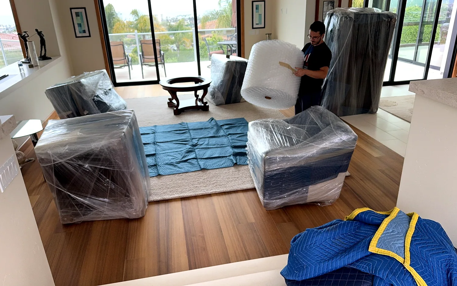 Wrapped furniture organized inside a home before moving and storage