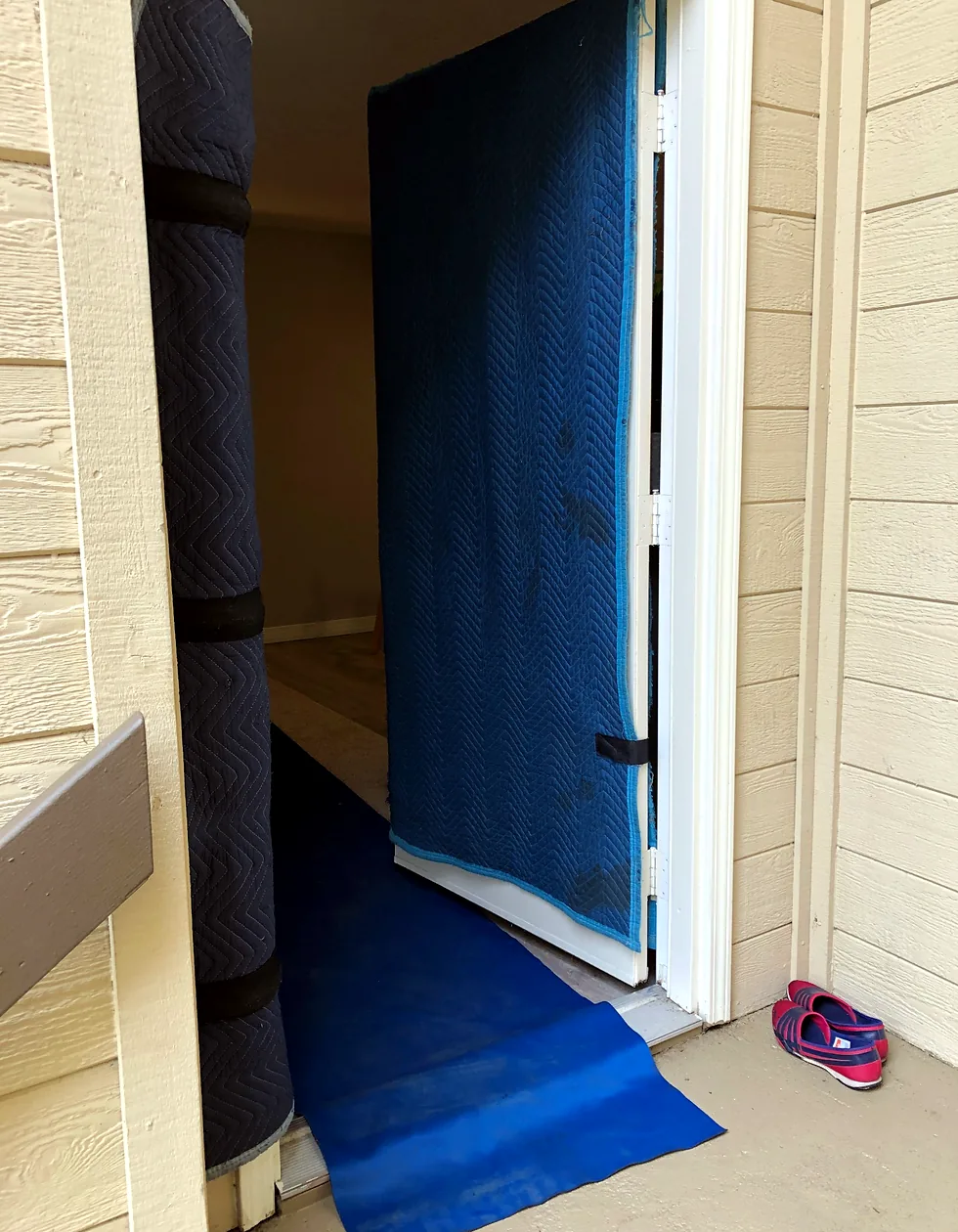 Moving blankets protecting a doorway while a floor runner covers the entry route