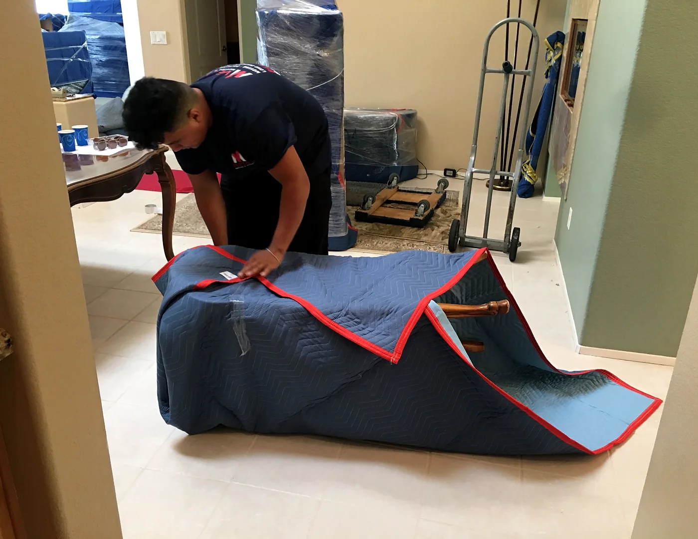 Vector mover securing a moving blanket around household furniture