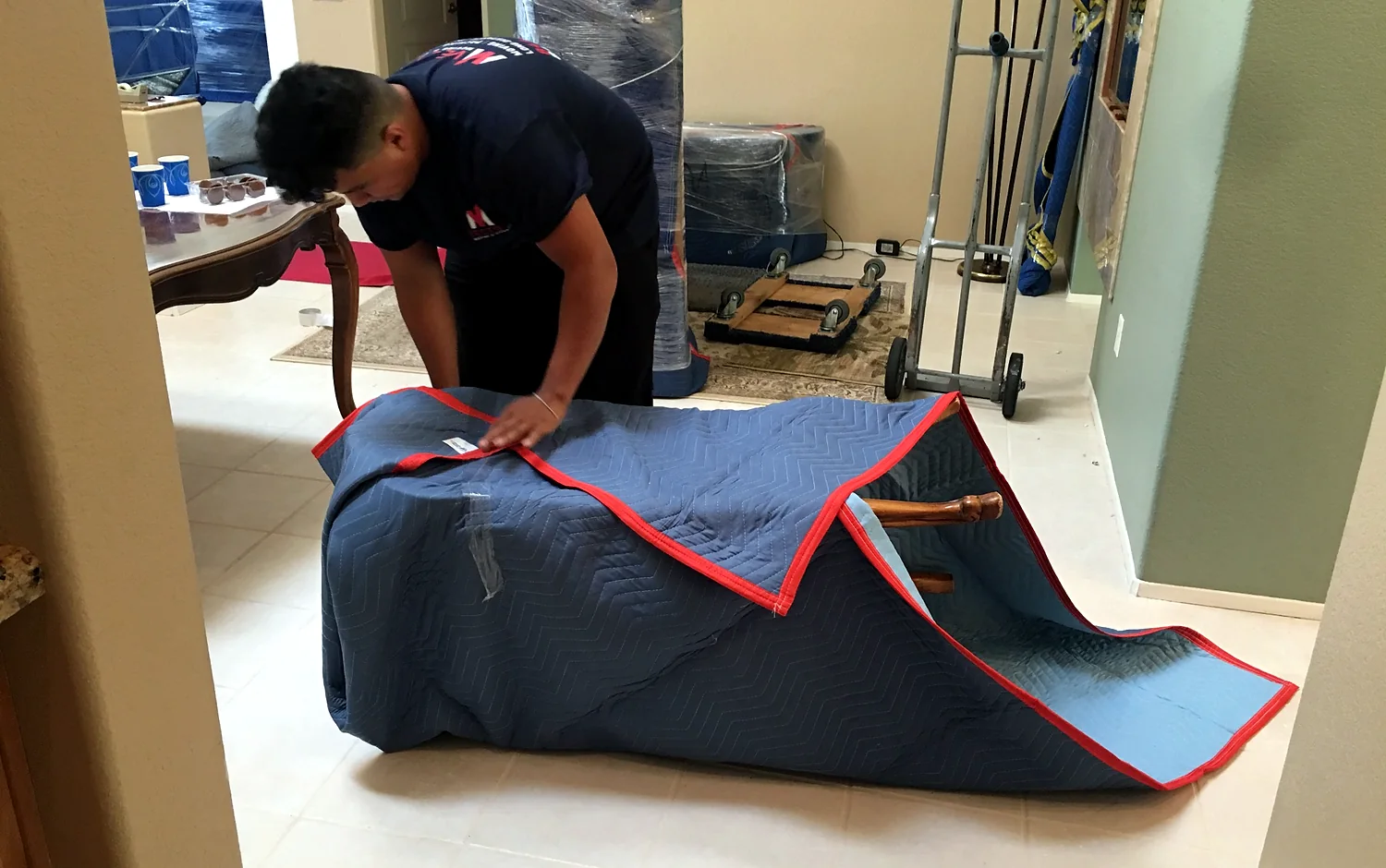Vector mover wrapping furniture with a quilted moving blanket