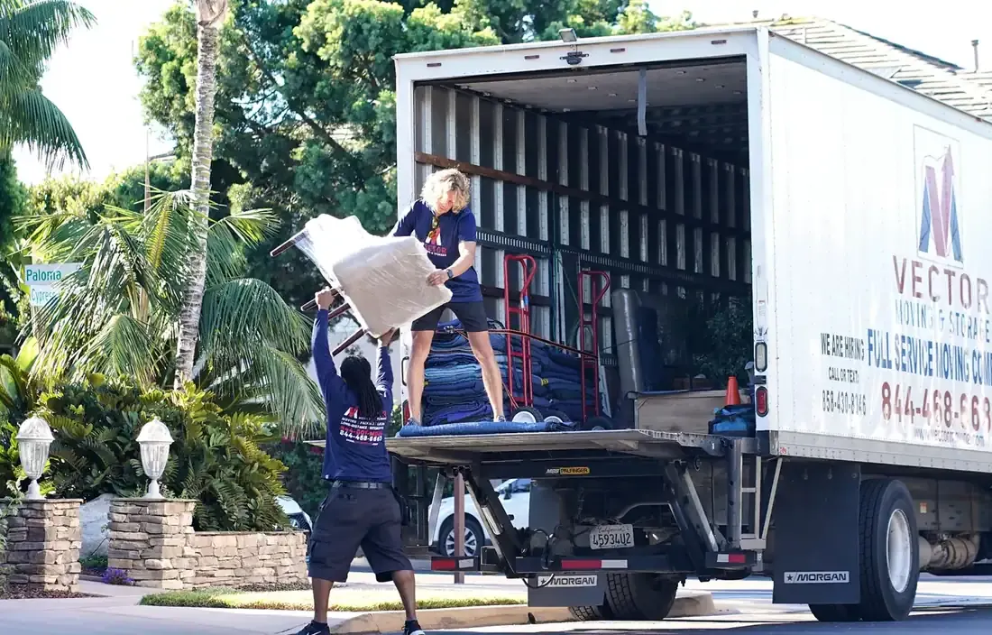 Vector movers transferring protected furniture at a home