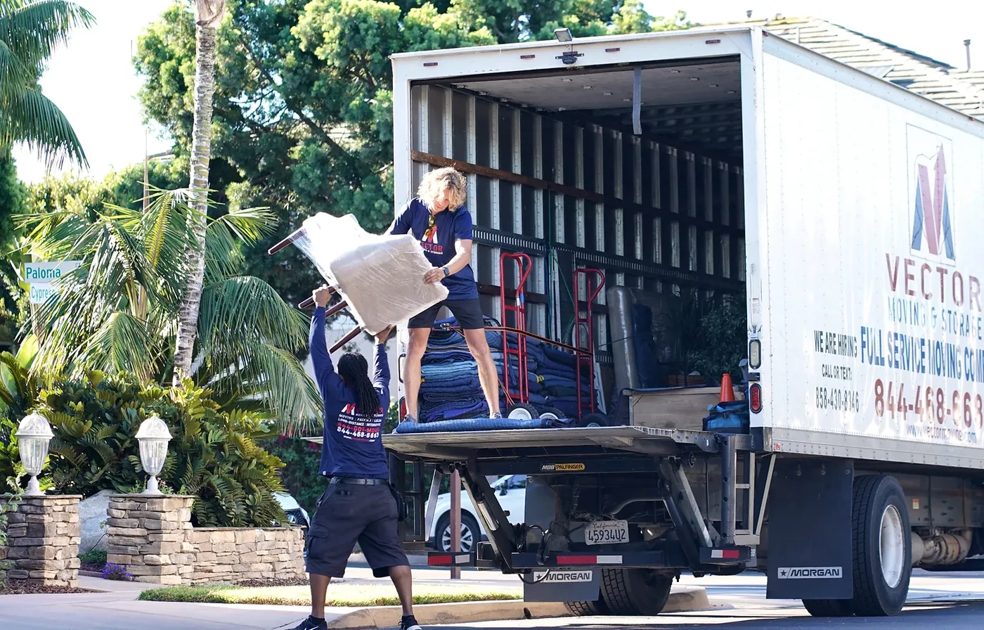 Vector movers transferring protected furniture at a San Diego home