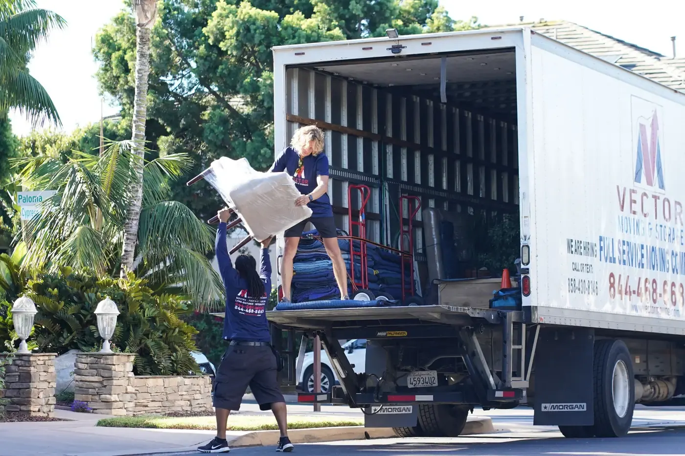 Vector moving crew loading protected furniture into a company truck