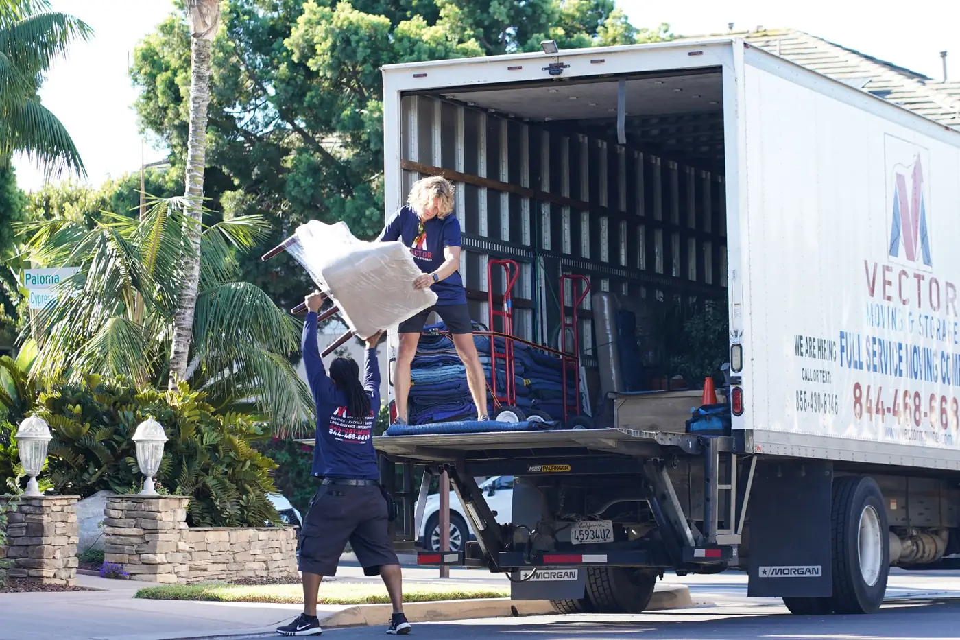 Vector moving crew loading protected furniture into a company truck