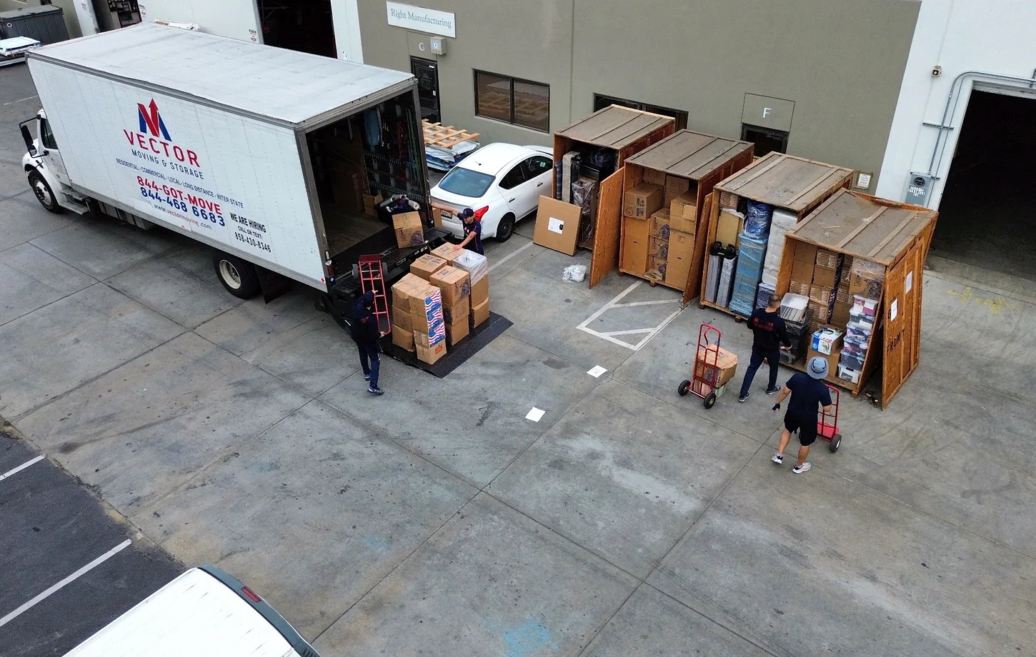 Vector crew staging packed household goods beside a moving truck and storage vaults