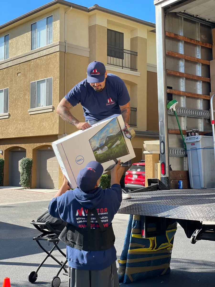 Vector movers loading packed household boxes into a moving truck
