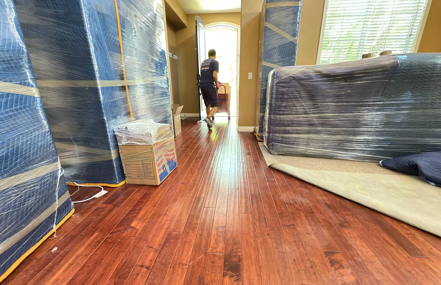 Vector movers preparing protected furniture inside a residence