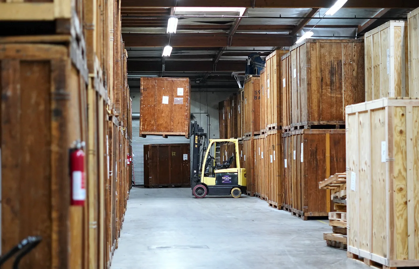 Wooden storage vaults and forklift inside the Vector Moving and Storage warehouse
