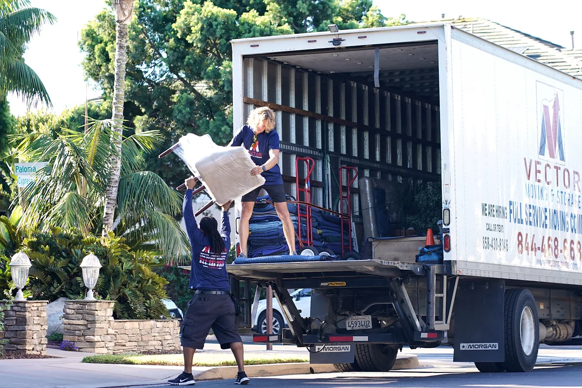 Vector movers transferring protected furniture during a residential move
