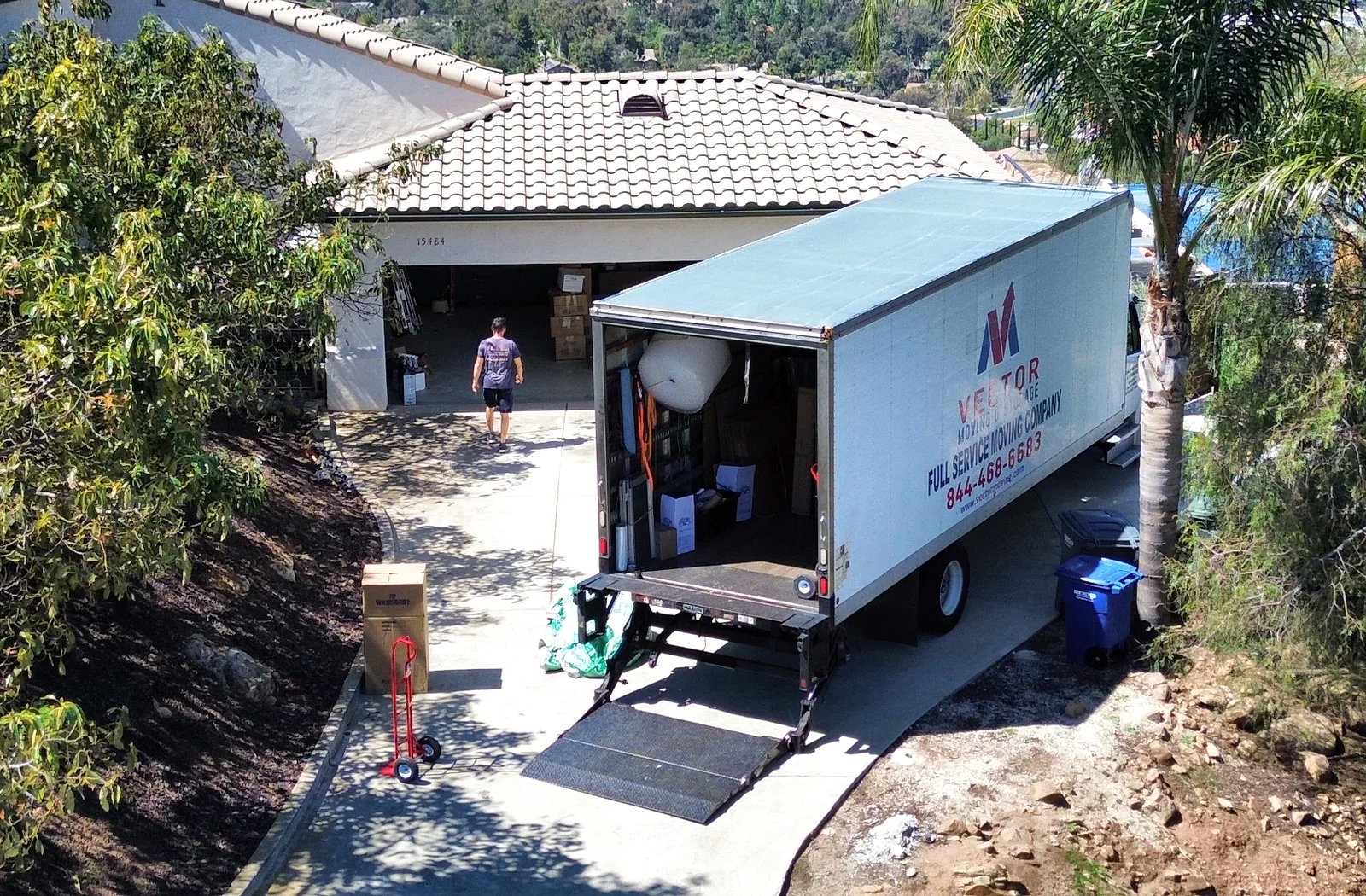 Vector moving truck at a hillside residential property