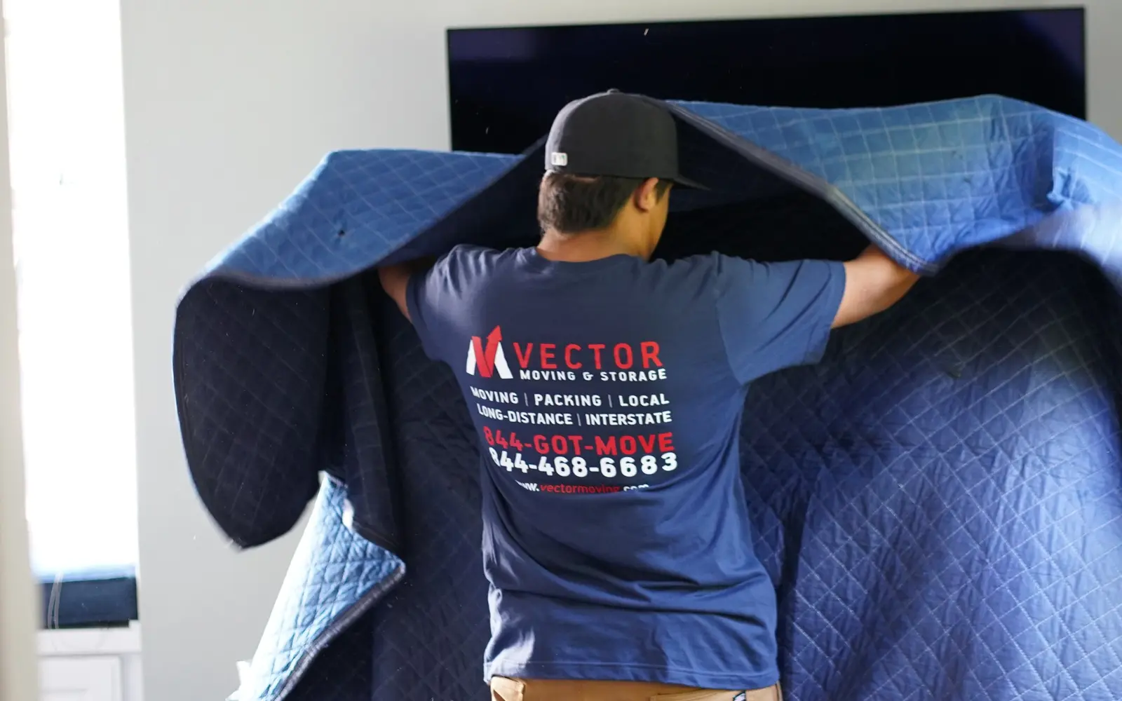 Real Vector mover wrapping large furniture with a professional moving blanket