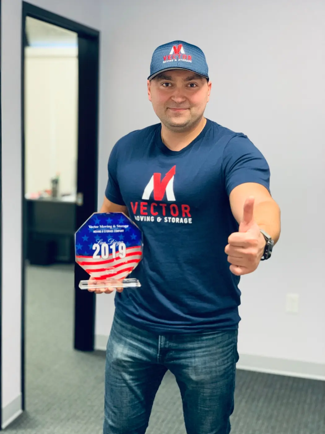Vector team member holding a historical local moving company recognition award