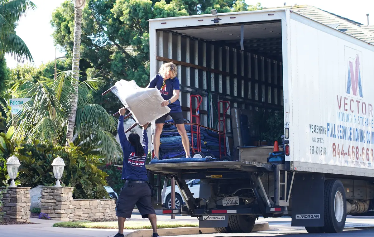 Vector moving crew loading furniture into a prepared moving truck