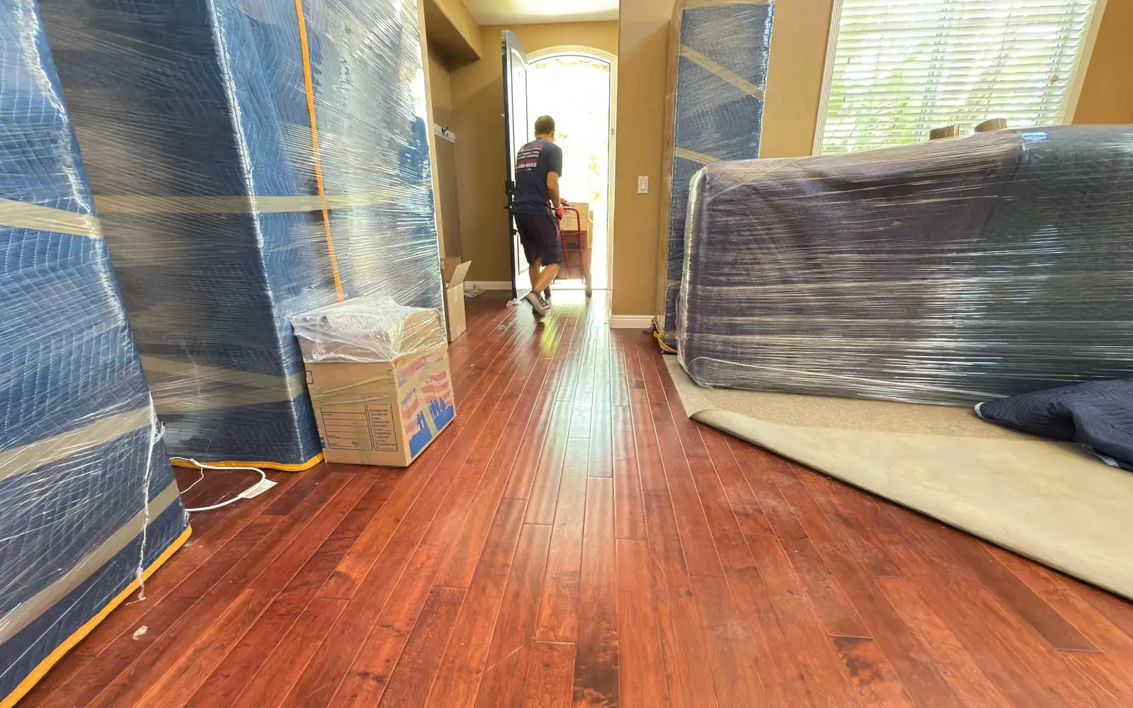 Wrapped household furniture inside a home before a Vector move