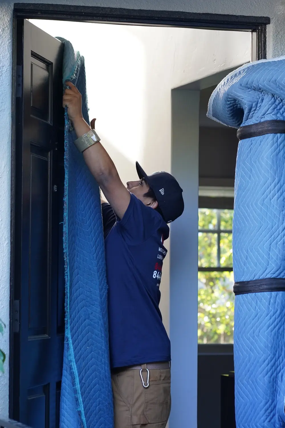 Real Vector mover installing protective moving blankets around a doorway
