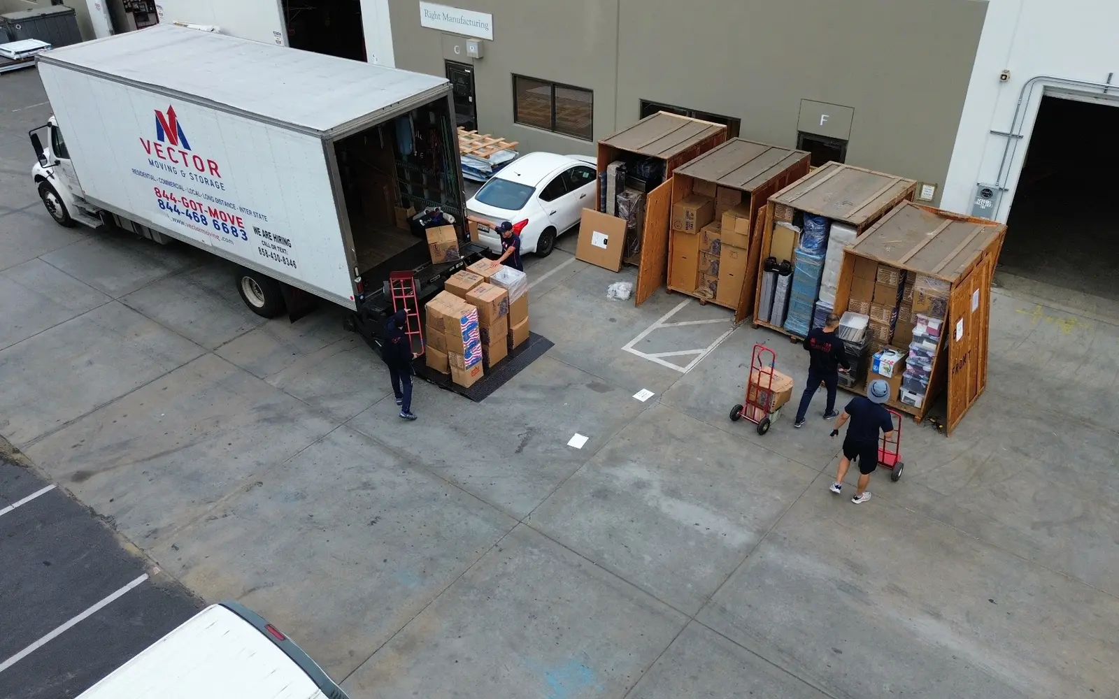 Real Vector crew transferring boxed contents between storage vaults and a moving truck