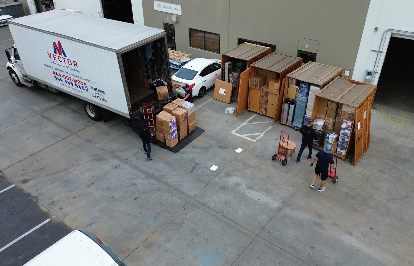 Vector crew transferring boxed inventory between storage vaults and a moving truck